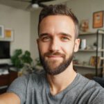 Close-up portrait of a young woman with brown hair and blue eyes smiling softly indoors